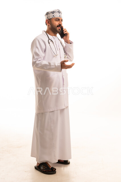 Omani Doctor Talking on Smartphone in White Studio