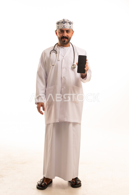 Omani Male Doctor Holding Smartphone in Studio Background