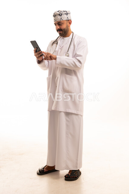 Omani Doctor in Traditional Dress Using Smartphone