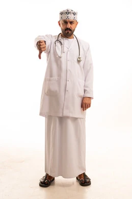 طبيب عماني يشير بعلامة الرفض أمام خلفية بيضاء