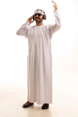 Omani Man in Traditional Dishdasha Listening to Music