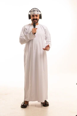 رجل عُماني باللباس التقليدي مع ميكروفون وسماعات استوديو