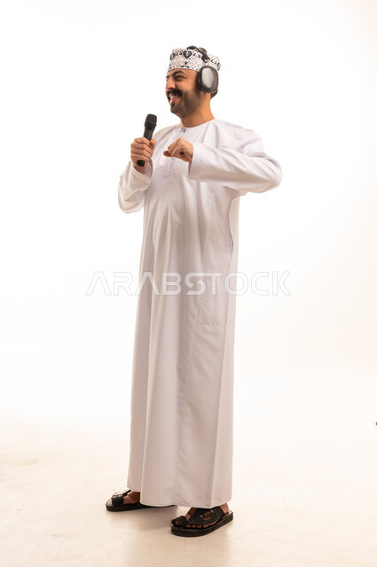 رجل عماني يغني مع ميكروفون وسماعات رأس