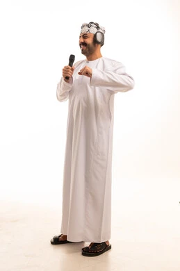 رجل عماني يغني مع ميكروفون وسماعات رأس