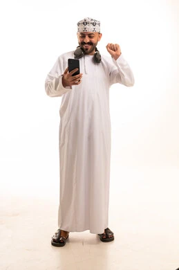 Omani Man with Smartphone Celebrating Success in Studio