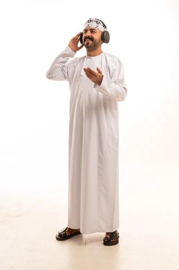 رجل عُماني يرتدي سماعات رأس على خلفية بيضاء