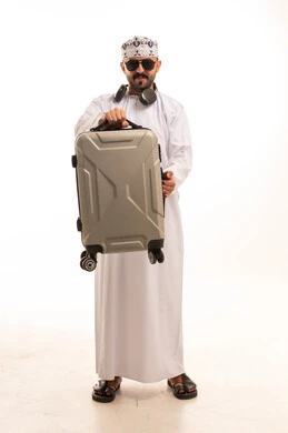 رجل عُماني بزي تقليدي يحمل حقيبة سفر