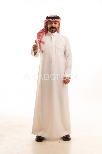 رجل سعودي بالزي التقليدي يشير بالإبهام للأعلى