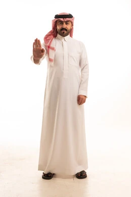 رجل سعودي يشير بحركة توقف بالزي التقليدي