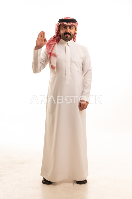 رجل سعودي بالزي التقليدي يلقي التحية خلفية بيضاء