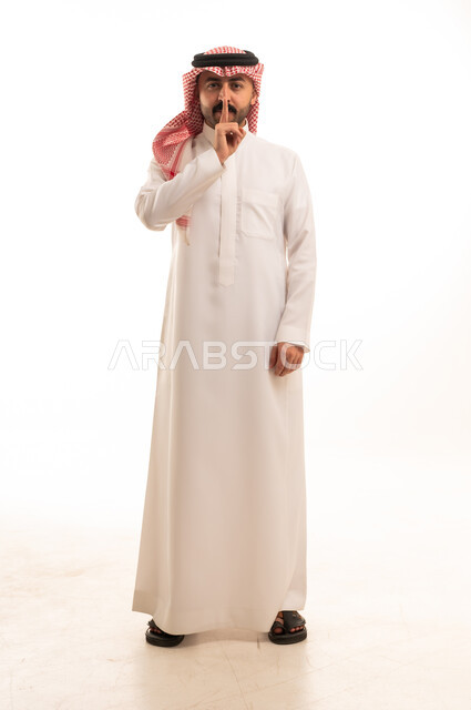 Saudi Man in Traditional Thobe Making Silence Gesture