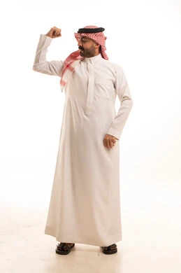 رجل سعودي بالثوب التقليدي يستعرض عضلات ذراعه