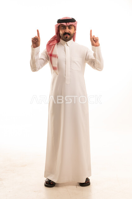 Saudi Arabian Man in Traditional Thobe Pointing Upwards