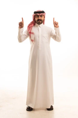 رجل سعودي بالثوب التقليدي والشماغ يشير بيده للأعلى