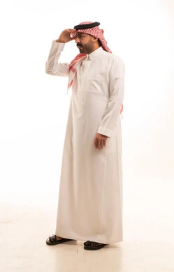 رجل سعودي بالزي التقليدي ينظر إلى الأفق بوضعية البحث