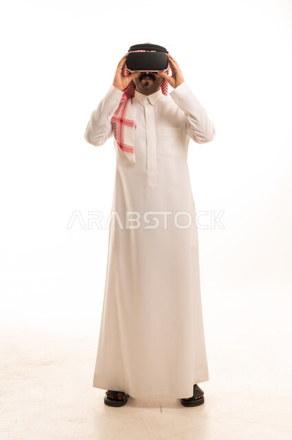 رجل سعودي يرتدي نظارة واقع افتراضي بالثوب التقليدي