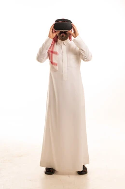 رجل سعودي يرتدي نظارة واقع افتراضي بالثوب التقليدي