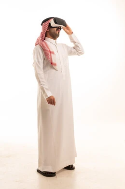 رجل سعودي بالزي التقليدي يستخدم نظارة الواقع الافتراضي
