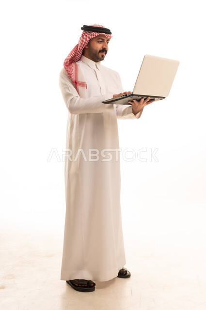 Saudi Man in Traditional Thobe Using Laptop on White