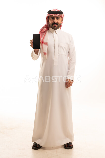Saudi Man in Traditional Thobe Holding Smartphone