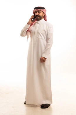 Saudi Man in Traditional Thobe Using Smartphone
