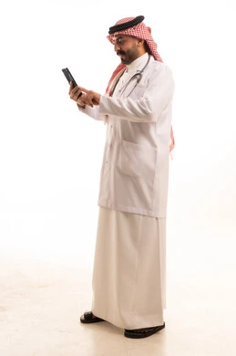 طبيب سعودي يستخدم الهاتف الذكي مع سماعة طبية في الاستوديو