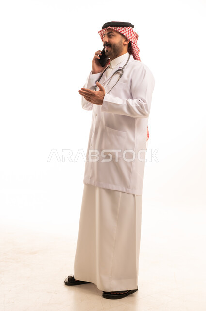 طبيب سعودي بالبالطو الأبيض يتحدث عبر الجوال
