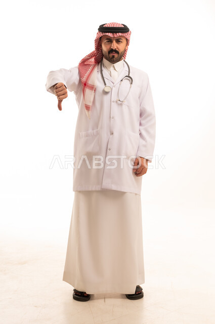 Saudi Doctor with Thumbs Down Gesture on White Background