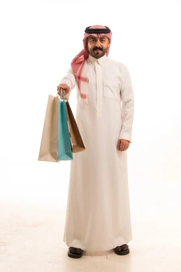 رجل سعودي يحمل أكياس تسوق في الاستوديو
