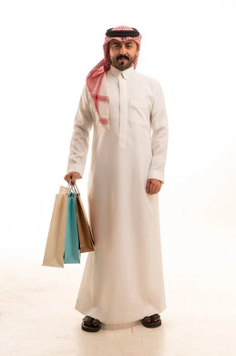 رجل سعودي يحمل أكياس تسوق بخلفية بيضاء