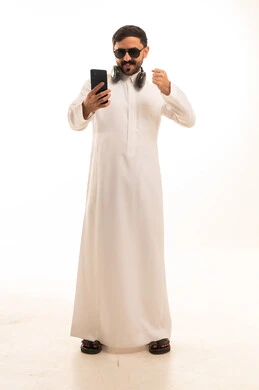 Saudi Man in Traditional Thobe Using Smartphone Studio