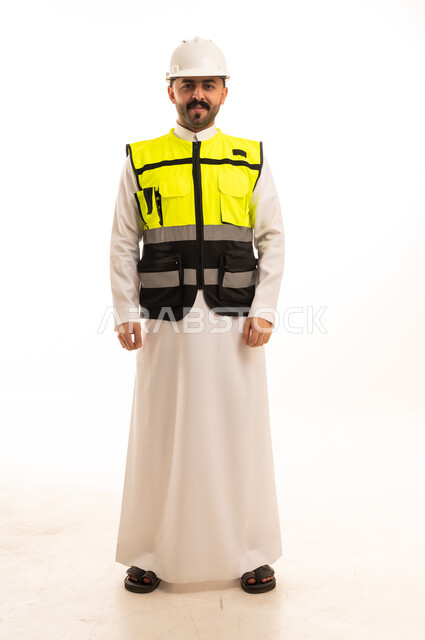 مهندس سعودي يرتدي الثوب الأبيض وسترة السلامة