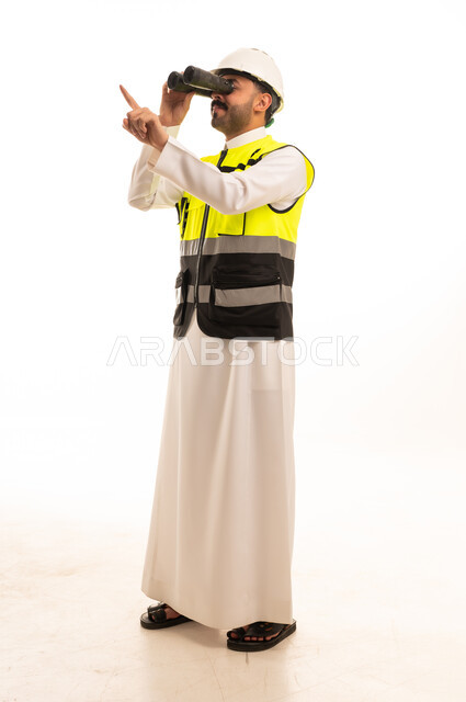 مهندس سعودي بمنظار وسترة سلامة خلفية بيضاء