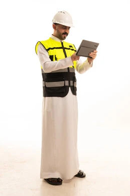 مهندس سعودي بالثوب يستخدم جهاز لوحي بخلفية بيضاء
