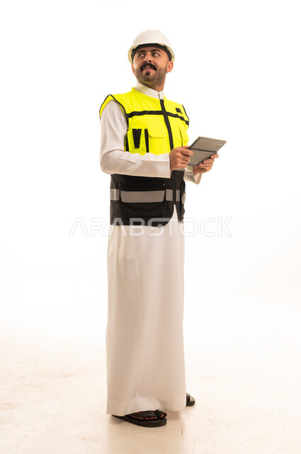 مهندس سعودي بالثوب يحمل جهازا لوحيا خلفية بيضاء
