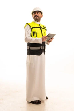 مهندس سعودي بالثوب يحمل جهازا لوحيا خلفية بيضاء