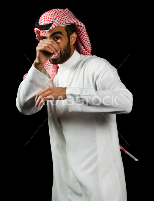 رجل عربي سعودي خليجي يرتدي الزي السعودي يقوم بحركات وتعابير تدل على الحركه العفويه والترفيه, ايماءات تدل على الملاكمه , تسليه ولعب, خلفيه سوداء