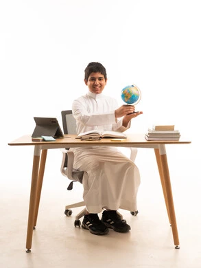 Saudi Boy Student in White Thobe with Desk Globe