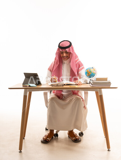 Saudi Student Studying at Desk with Tablet