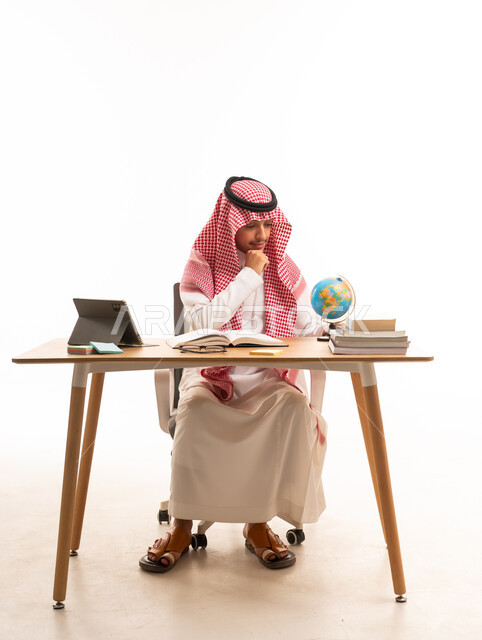 رجل سعودي على مكتب مع مجسم الكرة الأرضية