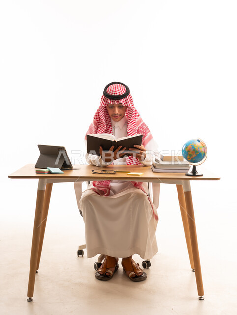 Young Saudi Student Reading at Desk on White Background