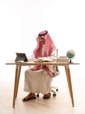 Saudi Man Working on Tablet at Desk