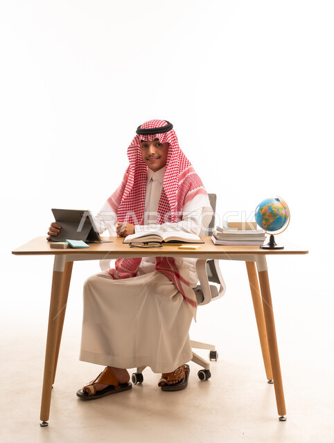 Saudi Student Studying at Desk with Tablet and Globe