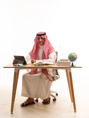 Saudi Student Studying at Desk with Tablet and Globe