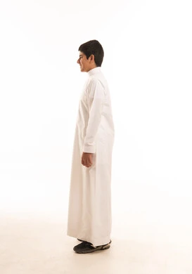 فتى سعودي بالثوب الأبيض التقليدي لقطة جانبية