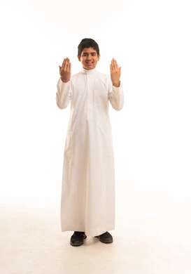 ولد سعودي بالثوب الأبيض يدعو أمام خلفية بيضاء