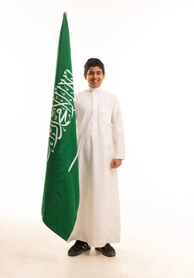 صبي سعودي يحمل علم المملكة العربية السعودية