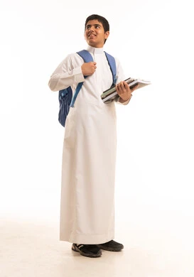 طالب سعودي بالثوب التقليدي يحمل حقيبة مدرسية وكتب دراسية