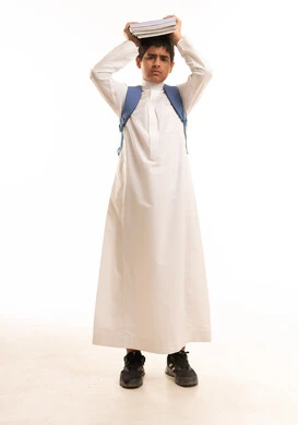 طالب سعودي بالثوب التقليدي يحمل كتباً فوق رأسه