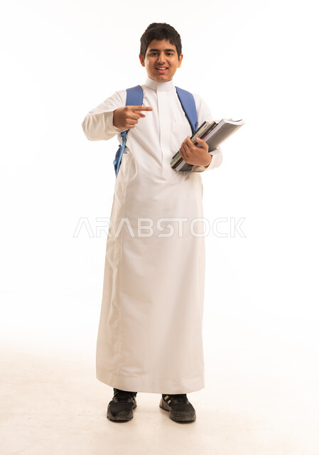 Saudi Student in White Thobe Holding School Books